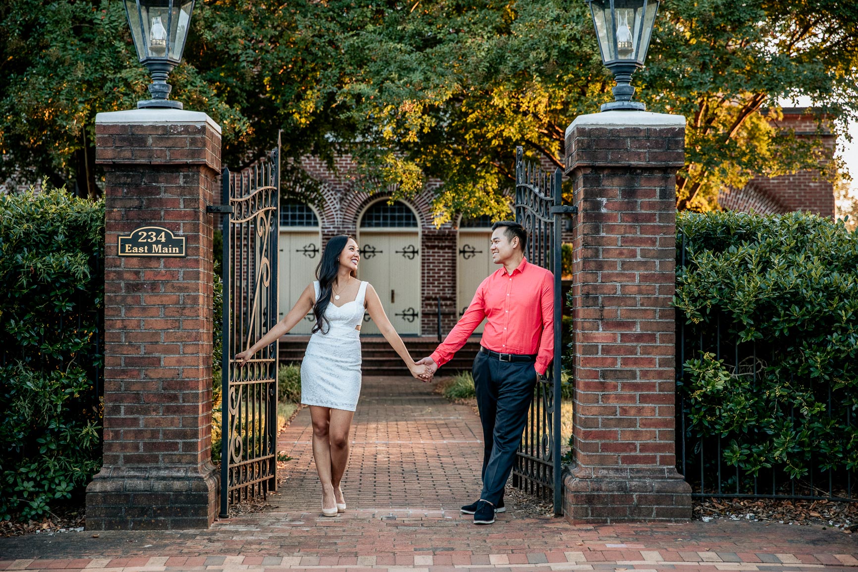 newly engaged couple wears a white dress with nude pumps and coral top for a rock hill sc engagement session shot by nhieu tang | nhieutang.com