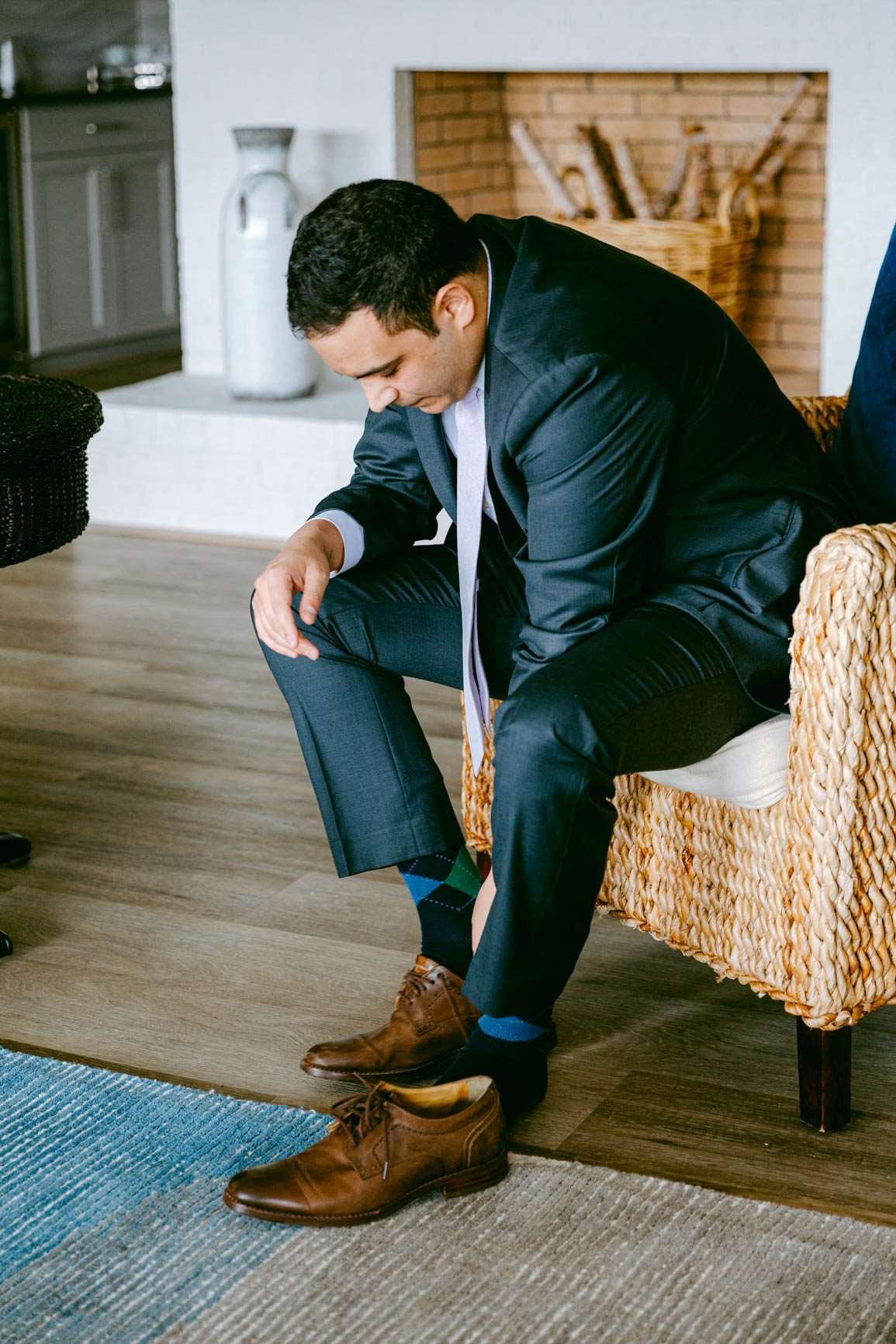 groom putting shoes on at a lake house elopement shot by Nhieu Tang Photography | nhieutang.com