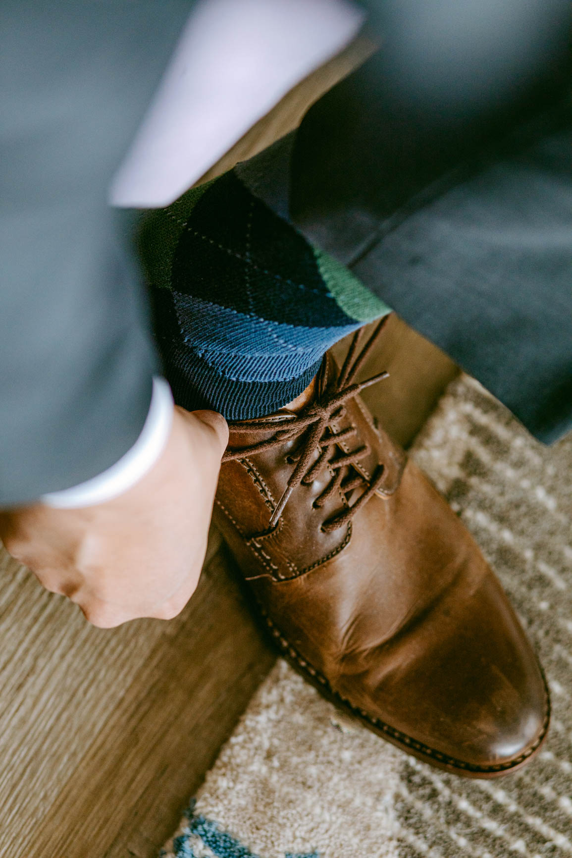 groom tying shoes at a lake house elopement shot by Nhieu Tang Photography | nhieutang.com