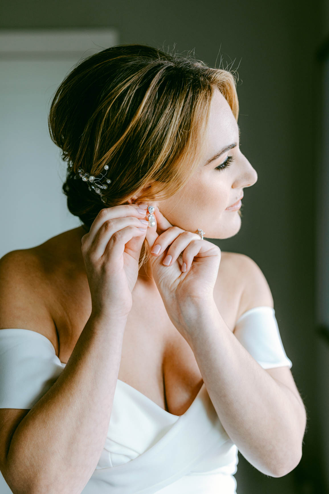 bride putting on earrings shot by Nhieu Tang Photography | nhieutang.com