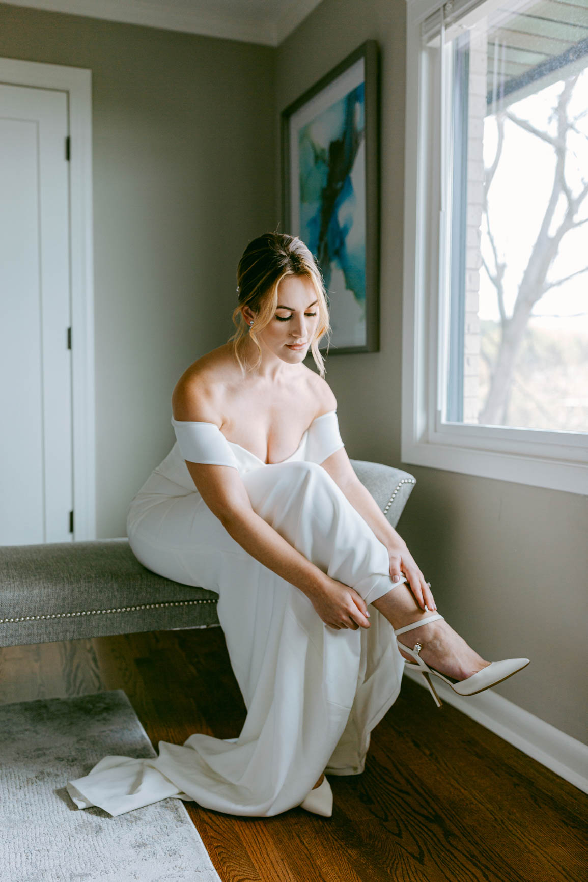 bride putting on shoes in Mooresville, NC lake house shot by Nhieu Tang Photography | nhieutang.com