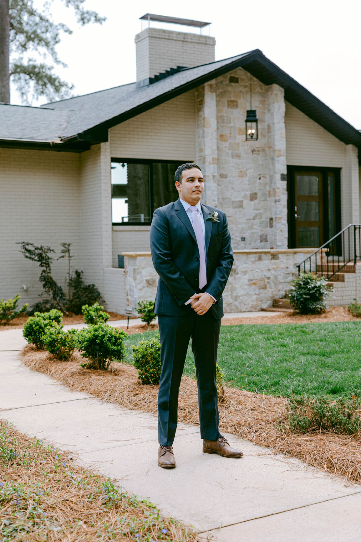 groom waiting outside for a first look in Mooresville, NC lake house shot by Nhieu Tang Photography | nhieutang.com