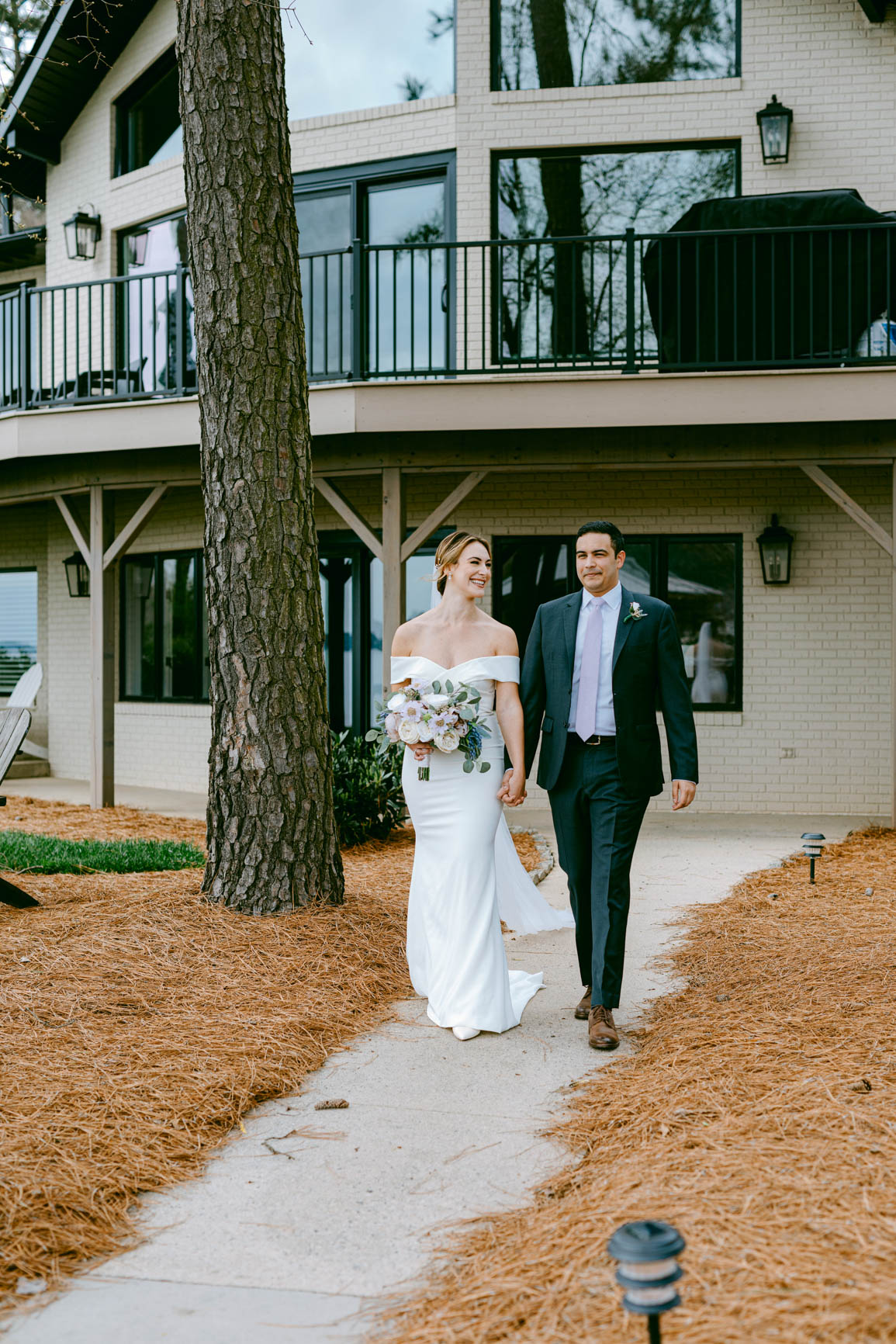 couple walking to ceremony in Mooresville, NC lake house shot by Nhieu Tang Photography | nhieutang.com
