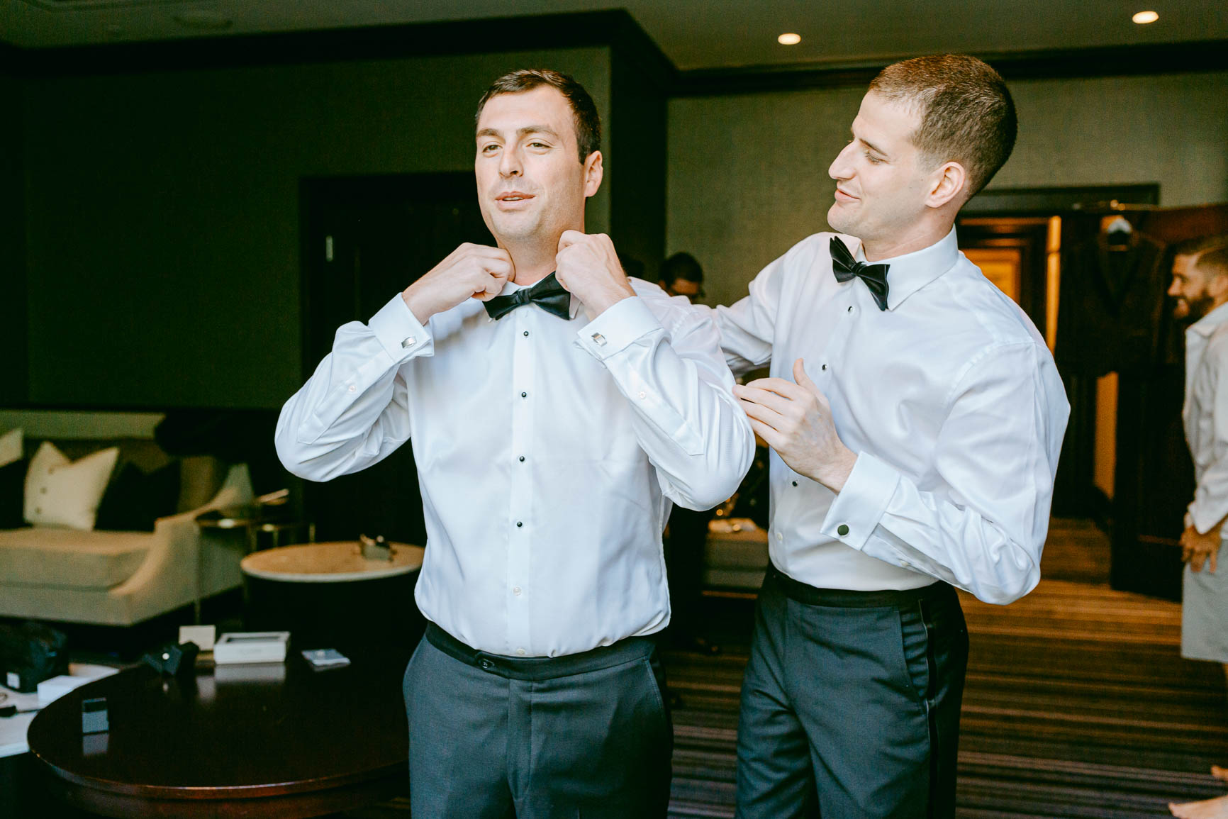 groom and groomsman getting ready in uptown Charlotte hotel shot by Nhieu Tang photography | nhieutang.com