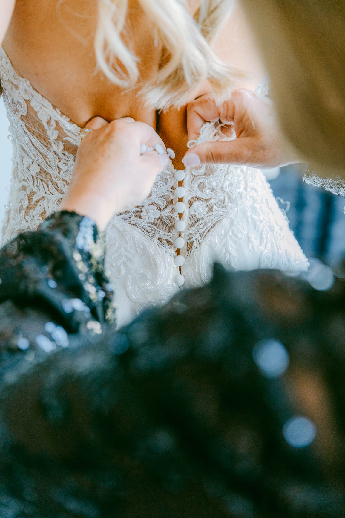Bride putting on lace dress shot by Nhieu Tang Photography | nhieutang.com