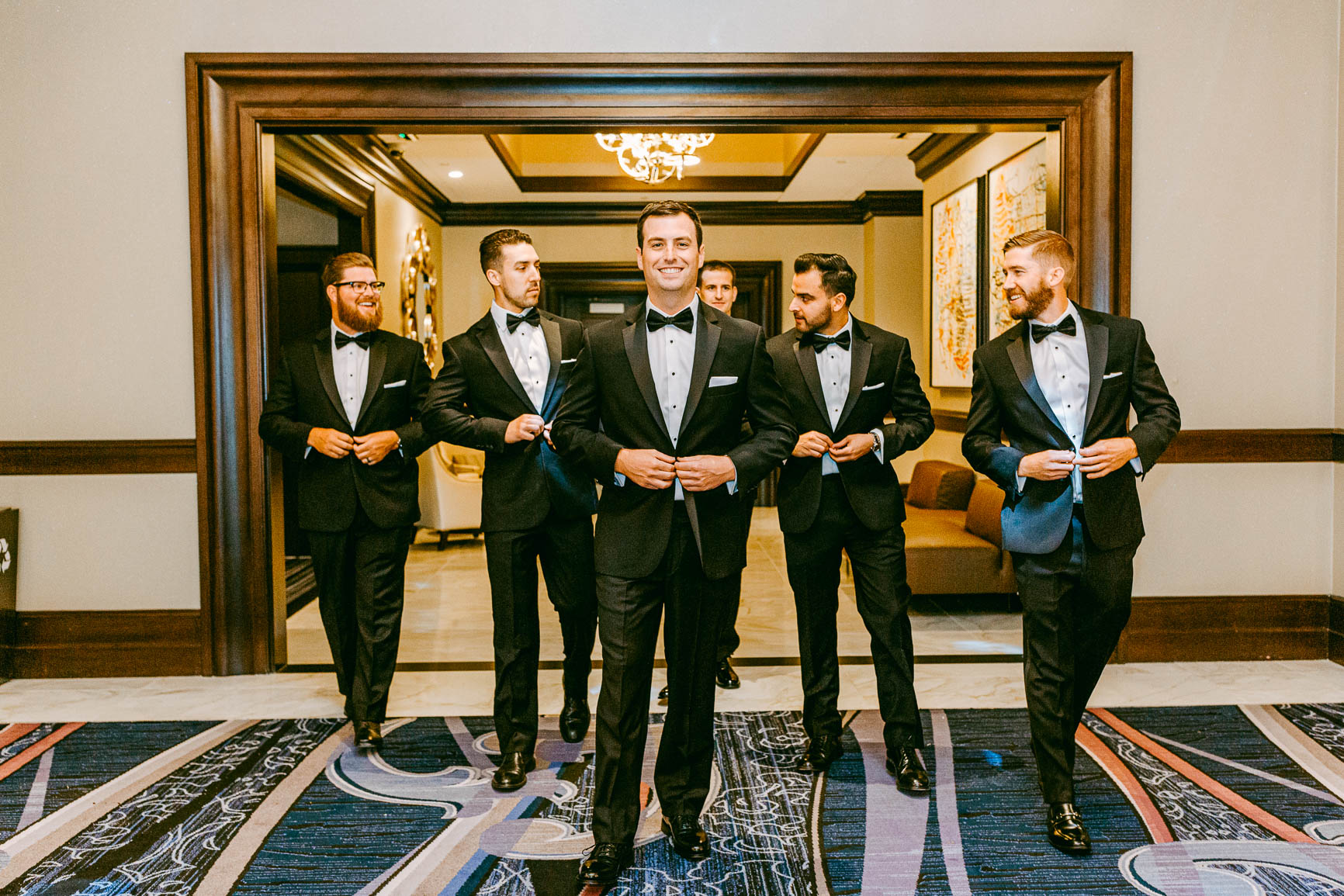 groom and groomsmen walking together at the Kimpton Tryon park hotel in Charlotte NC by Nhieu Tang Photography | nhieutang.com